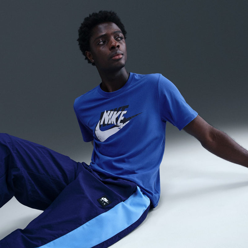 Men's blue T-shirt with Nike logo on front, sitting pose