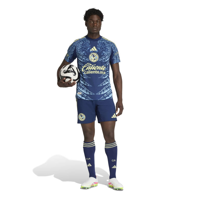Men's Club America away jersey on model, navy with leaf pattern and gold sponsor logos.