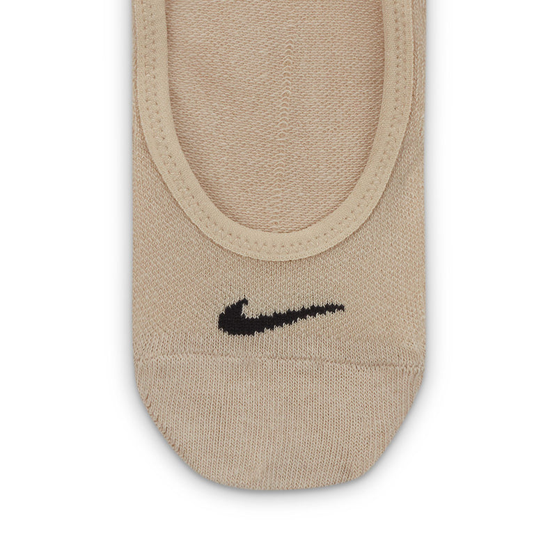 Tan lightweight footie sock close-up with black Nike swoosh on the front