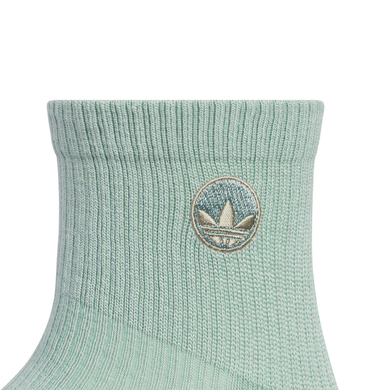 Hazy green quarter crew sock cuff with circular logo patch