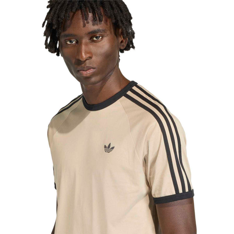 Close-up stone khaki raglan tee with black collar, three stripe detail on shoulder, trefoil logo