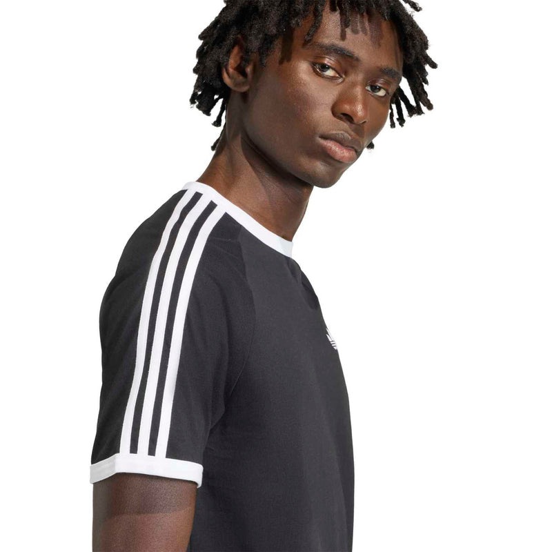 Black men's crewneck T-shirt with white three-stripe sleeve band and trefoil logo