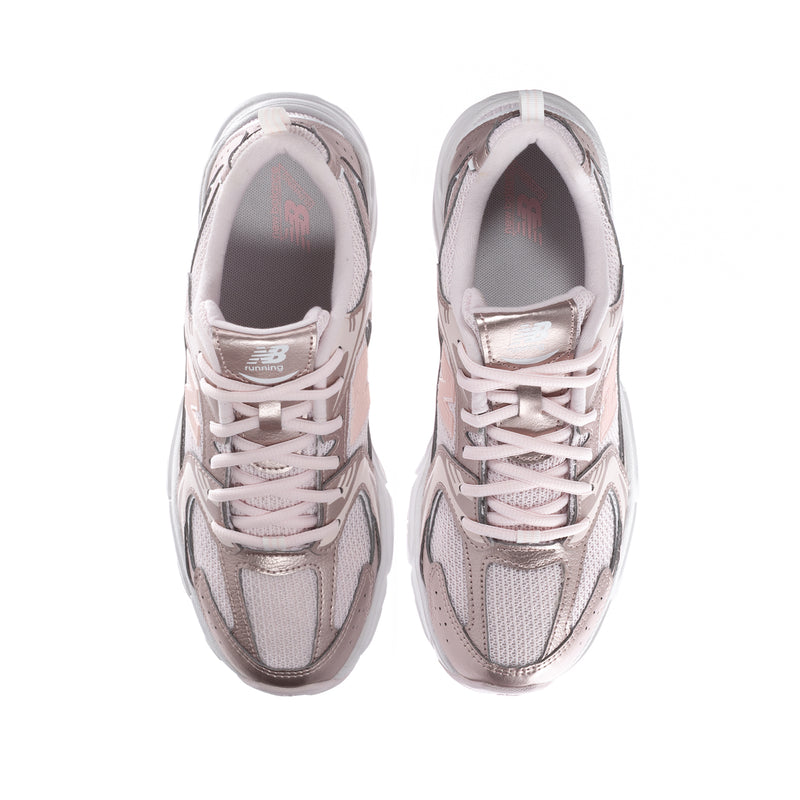 Youth pair of light pink sneakers, front view with lace-up closure and padded collars.