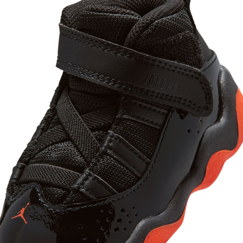 Black toddler sneaker upper close-up with hook-and-loop strap and red lining detail