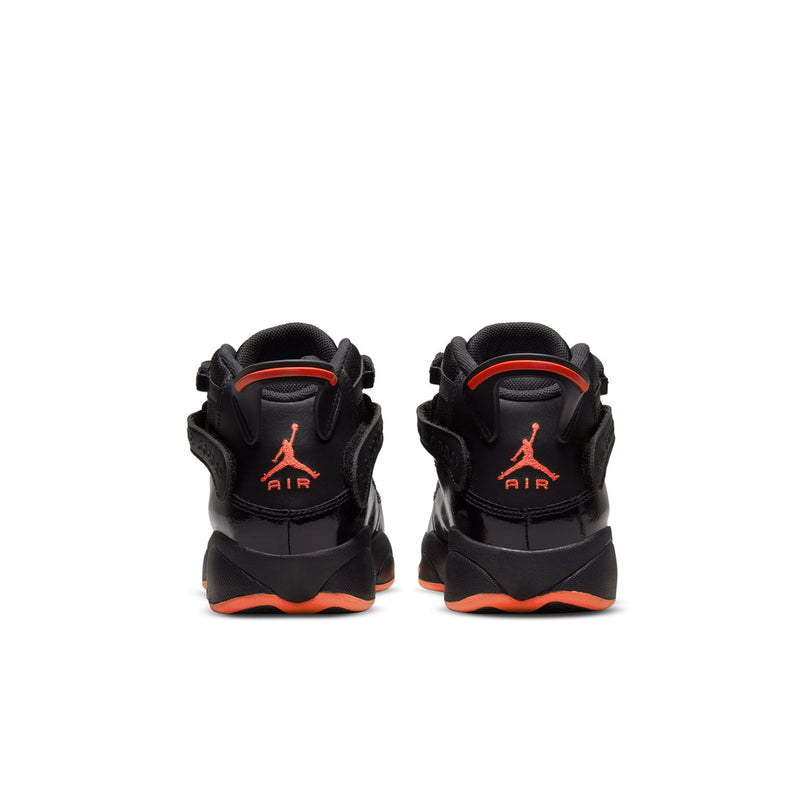 Youth black high-top sneakers showing rear heel with Jumpman logo and orange outsole