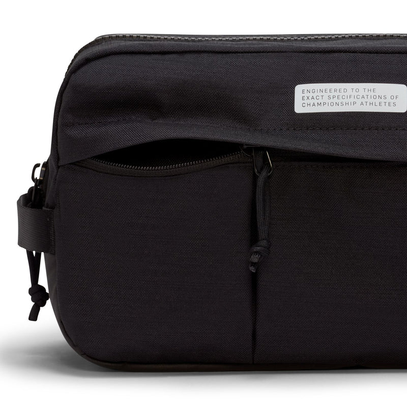 Black soccer shoe bag close-up with front pocket zipper and small text patch