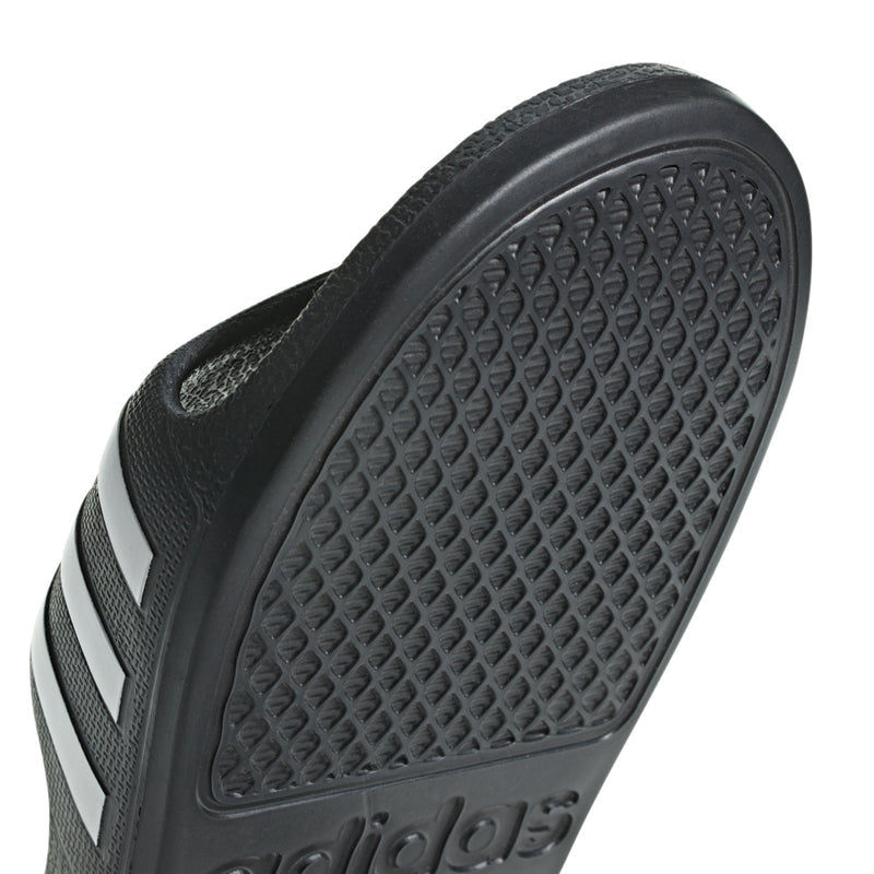 Kids black slide sandal outsole close-up with textured traction dots