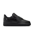 Women's black low-top sneaker with Nike swoosh and lace-up studded charms