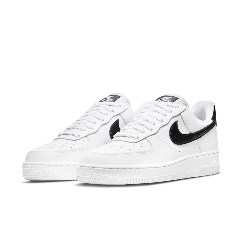 Pair of women’s white low-top sneakers with black Nike Swoosh and white laces