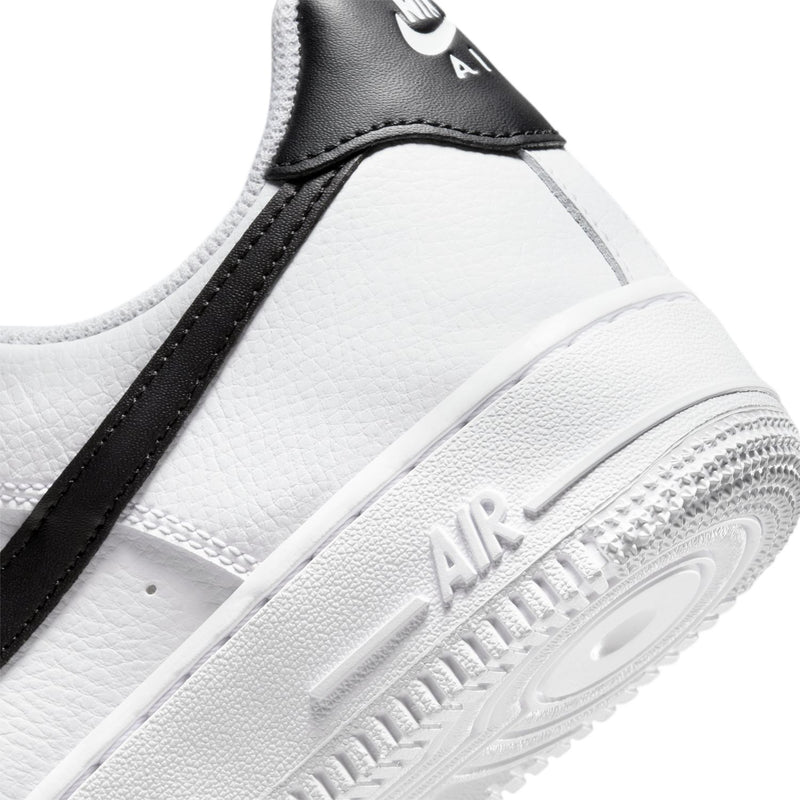 White sneaker side detail with black stripe, Air logo, and textured rubber sole