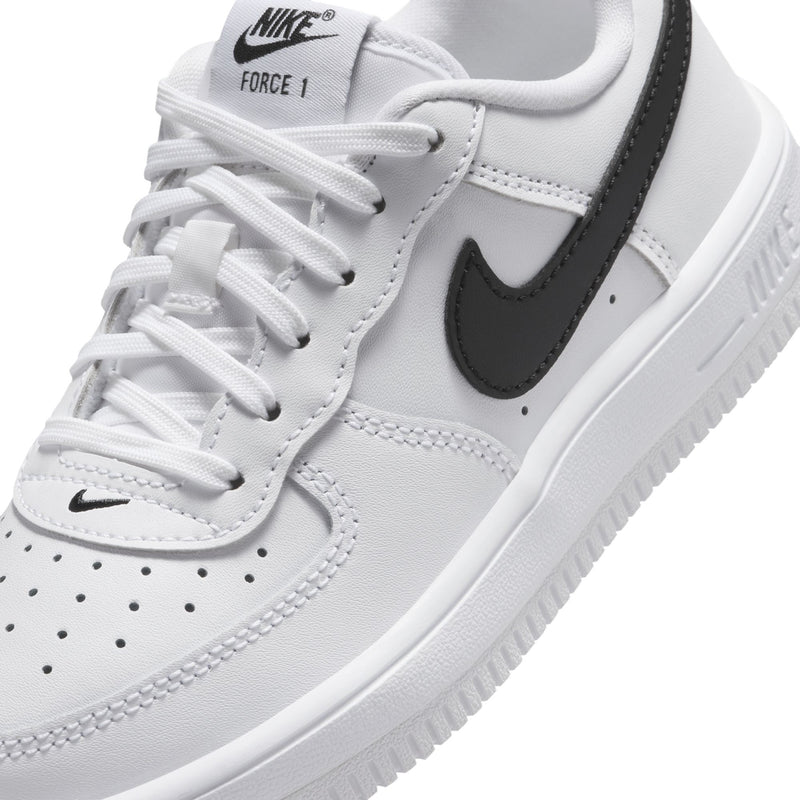 Kids' white sneaker upper with Nike swoosh, lace-up close-up