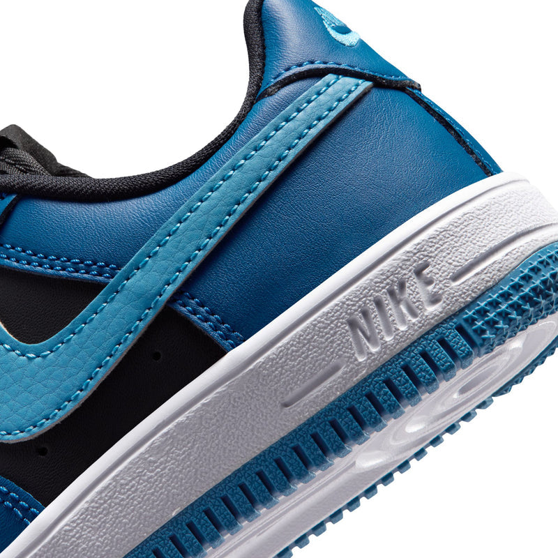Kids Nike Air Force 1 sneakers close-up, white midsole with Nike text and blue outsole