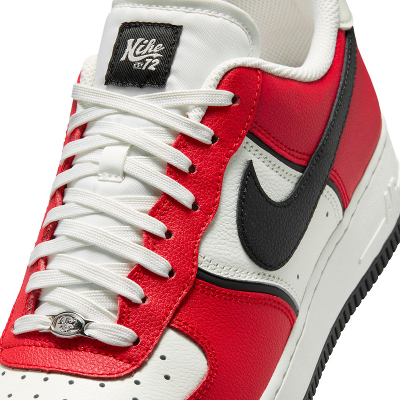 Close-up of men's sneaker laces on red leather with black swoosh and white perforations