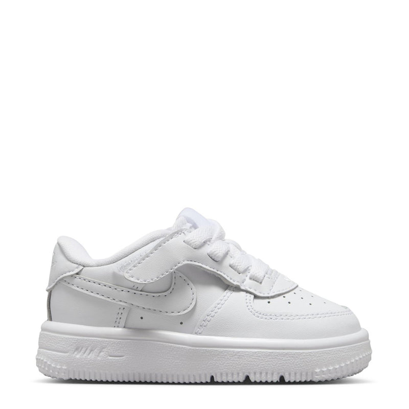 White toddler low-top sneakers with Nike swoosh and side panel stitching