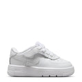 White toddler low-top sneakers with Nike swoosh and side panel stitching