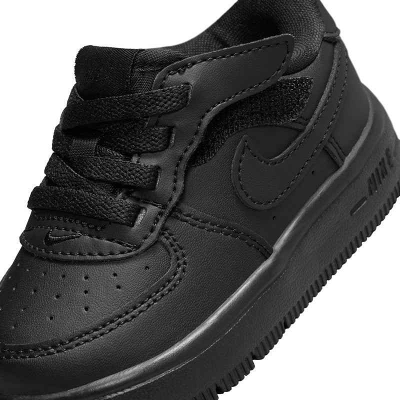 Toddler black sneaker upper close-up with swoosh logo and perforated toe