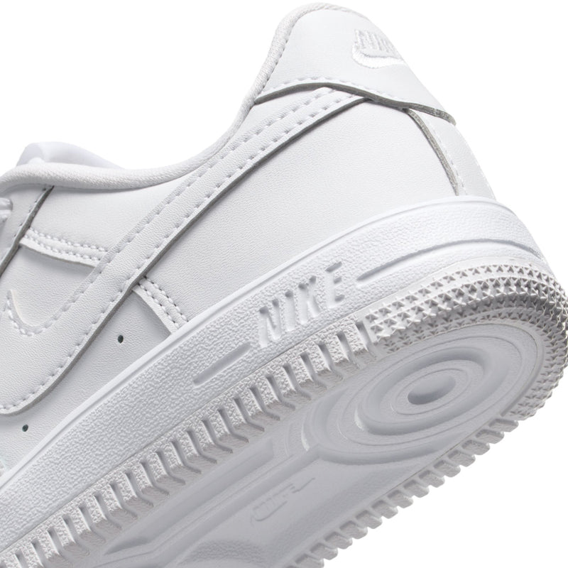 Kids white sneaker close-up of midsole with traction text and side swoosh