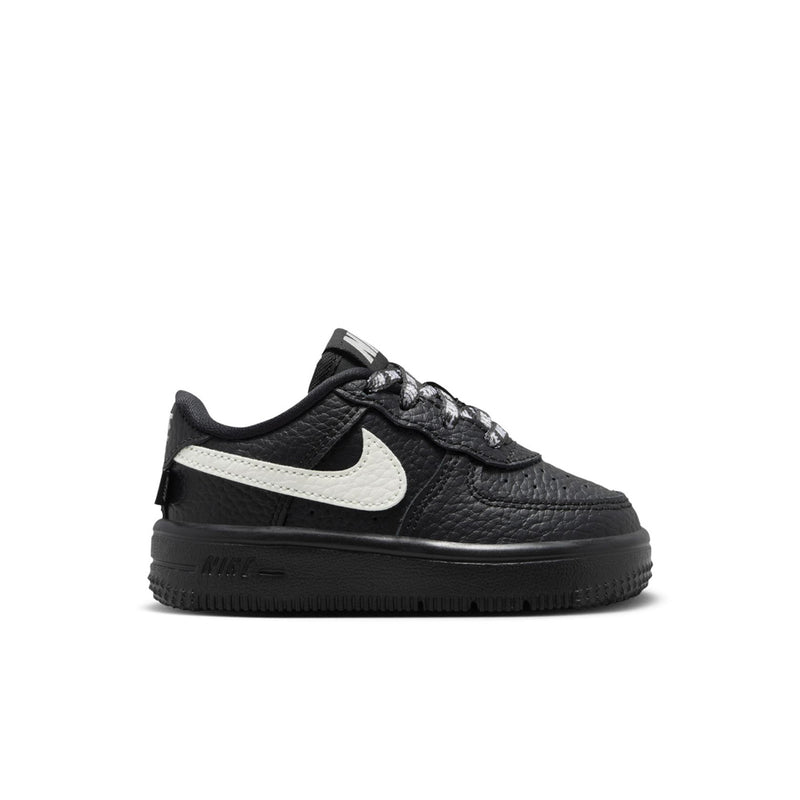 Black toddler low-top sneaker with white swoosh and black rubber sole
