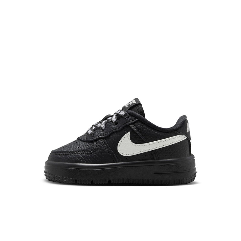Black toddler low-top sneaker with white swoosh and thick black outsole