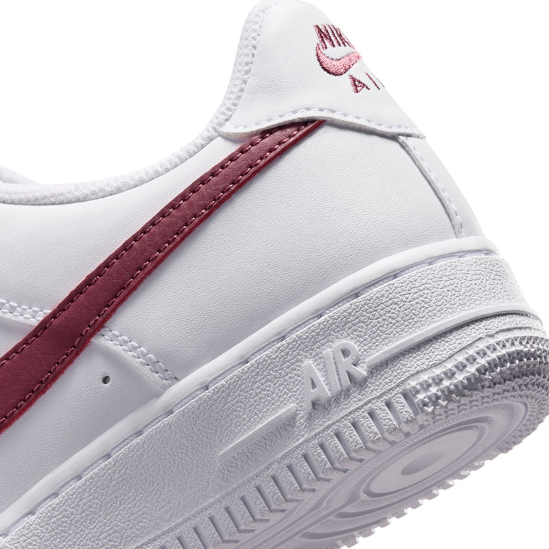 Youth low-top sneakers close-up, white upper with burgundy stripe and Air sole