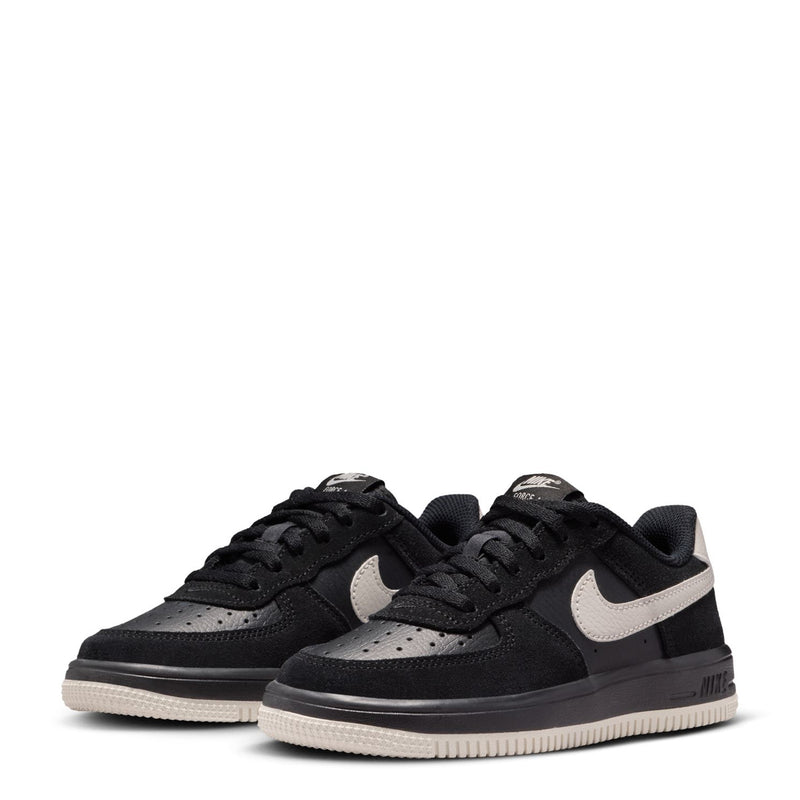 Pair of kids black lace-up sneakers with light bone swooshes and cream sole