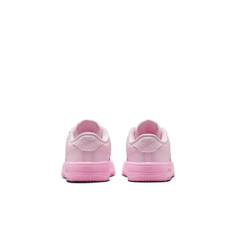 Pink toddler sneakers from the heel view with textured midsole and lace loops