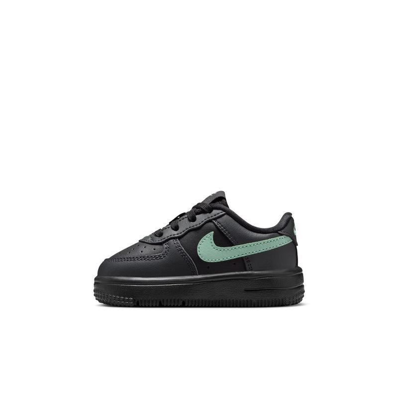 Toddler low-top sneaker side view, black leather with mint green swoosh and stitching