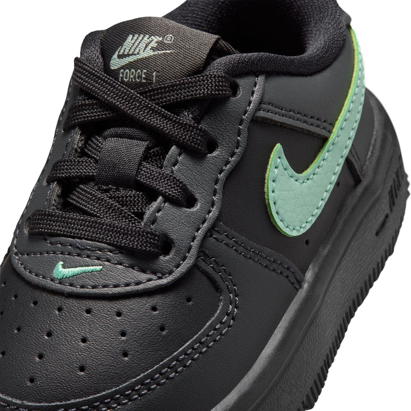 Toddler Nike sneaker close-up, black mesh tongue and mint green swoosh on side