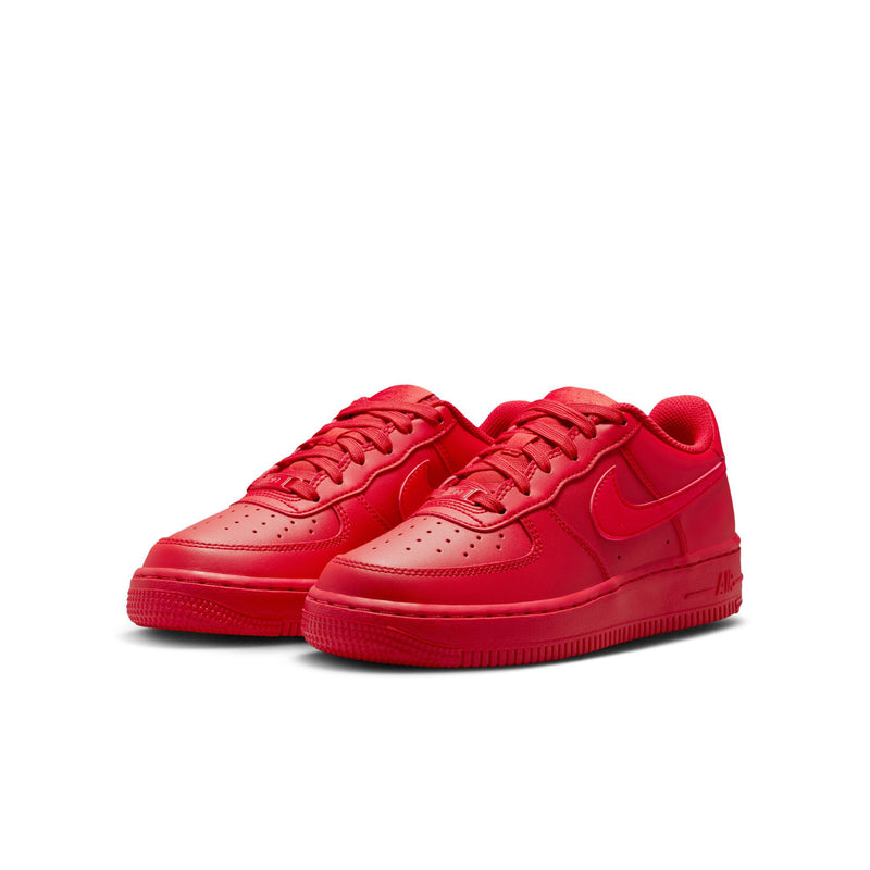 Pair of red youth low-top lace-up sneakers with Nike swoosh and perforations