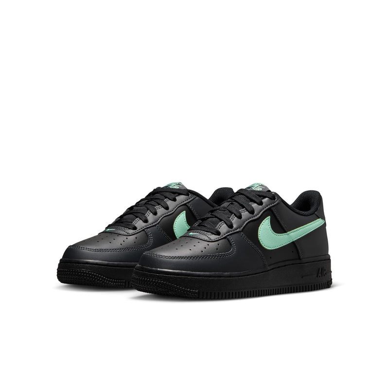 Pair of black youth low-top sneakers with mint green Swoosh and black rubber outsole.