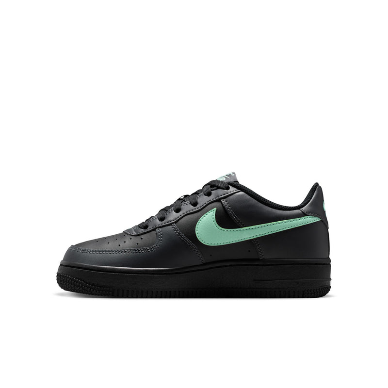 Black youth low-top sneakers with mint green Swoosh panel and perforated toe.