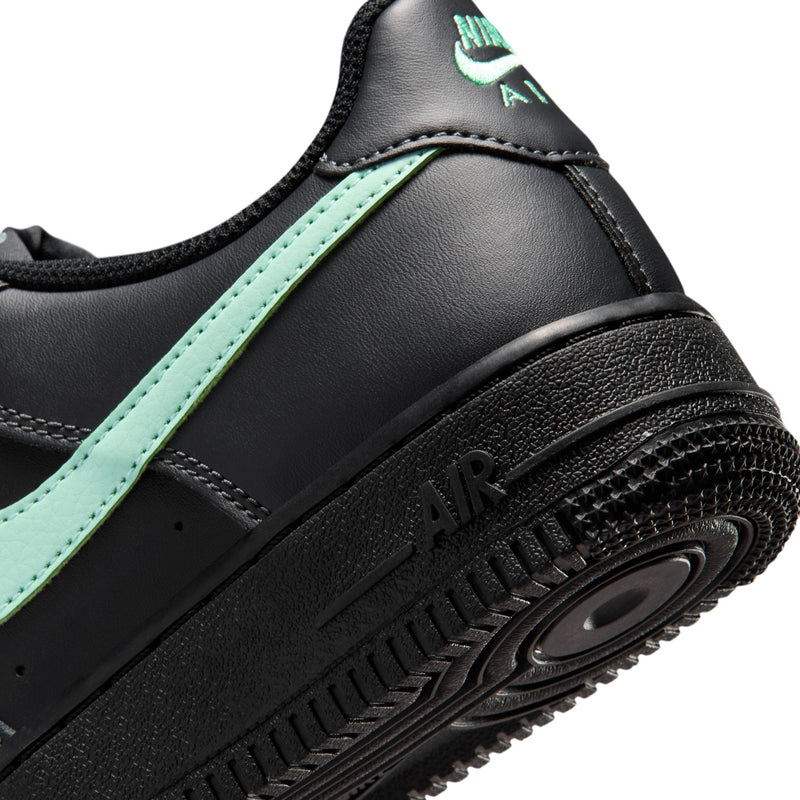 Close-up of black midsole and Air window with mint green stripe on youth sneakers.