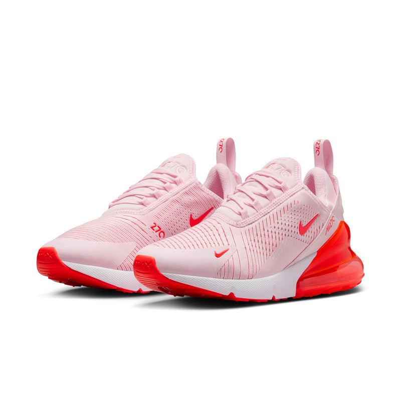 Women's light pink running shoe with red Air sole and Nike swoosh on sides