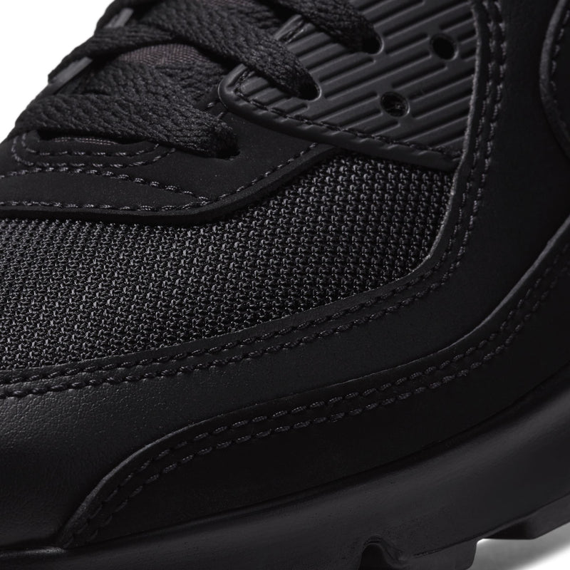 Close-up of black Nike sneaker upper with mesh, stitched overlays, and lace eyelets