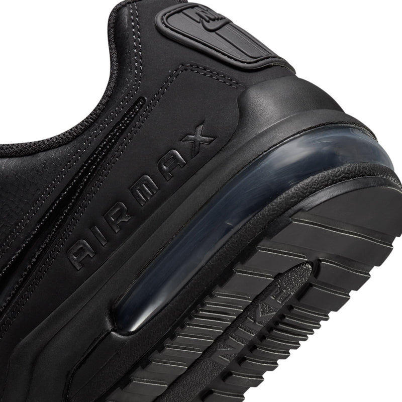 Black Air Max sneaker side close-up with 'AIR MAX' logo and dark outsole tread.