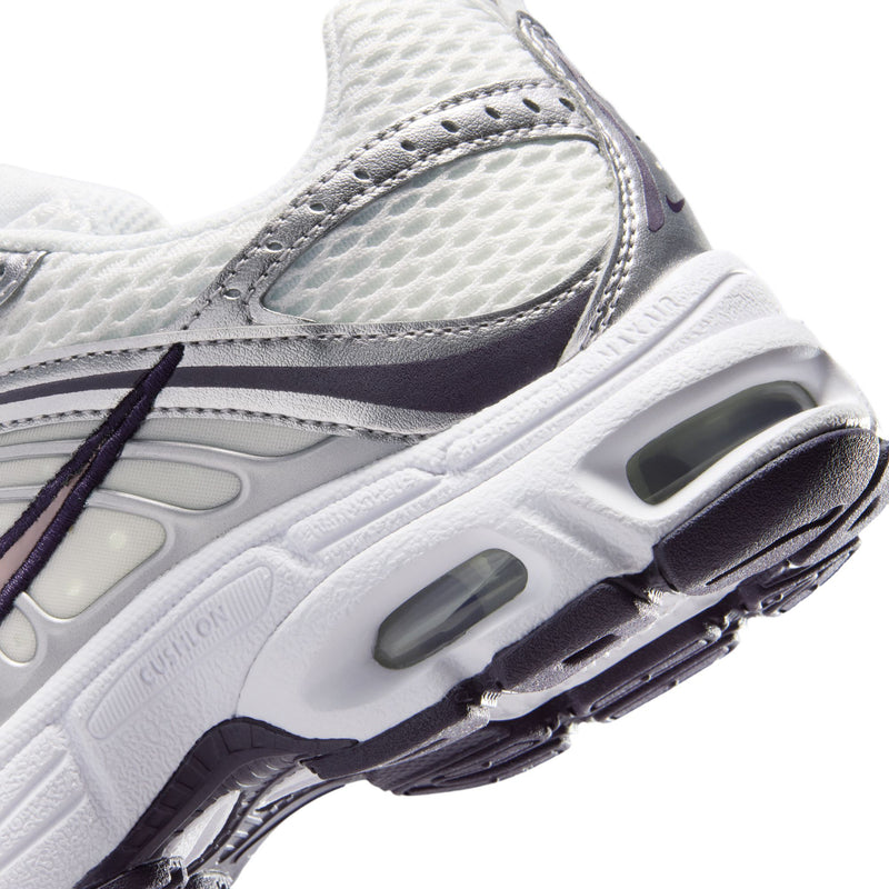 Close-up of youth white sneaker midsole with air cushioning pods and purple outsole edge