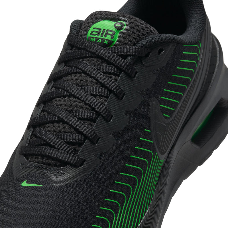 Close-up of men's black upper with green lace accents, Air Max logo, and Nike swoosh