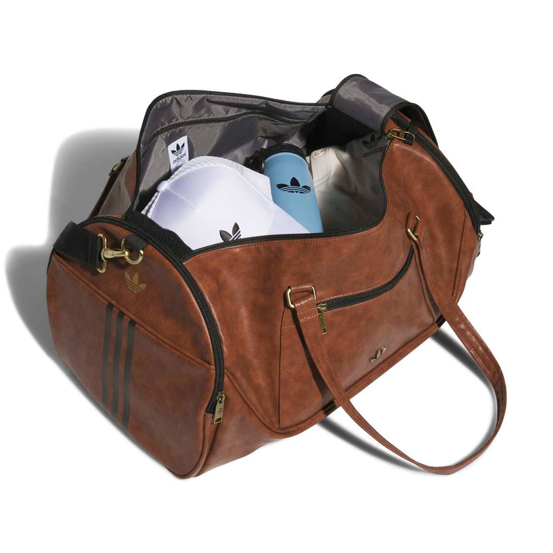 Brown duffel bag open, showing interior compartments and zippered side pocket