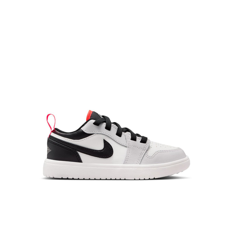 Kids low-top sneakers in white with black overlays and red lace accents