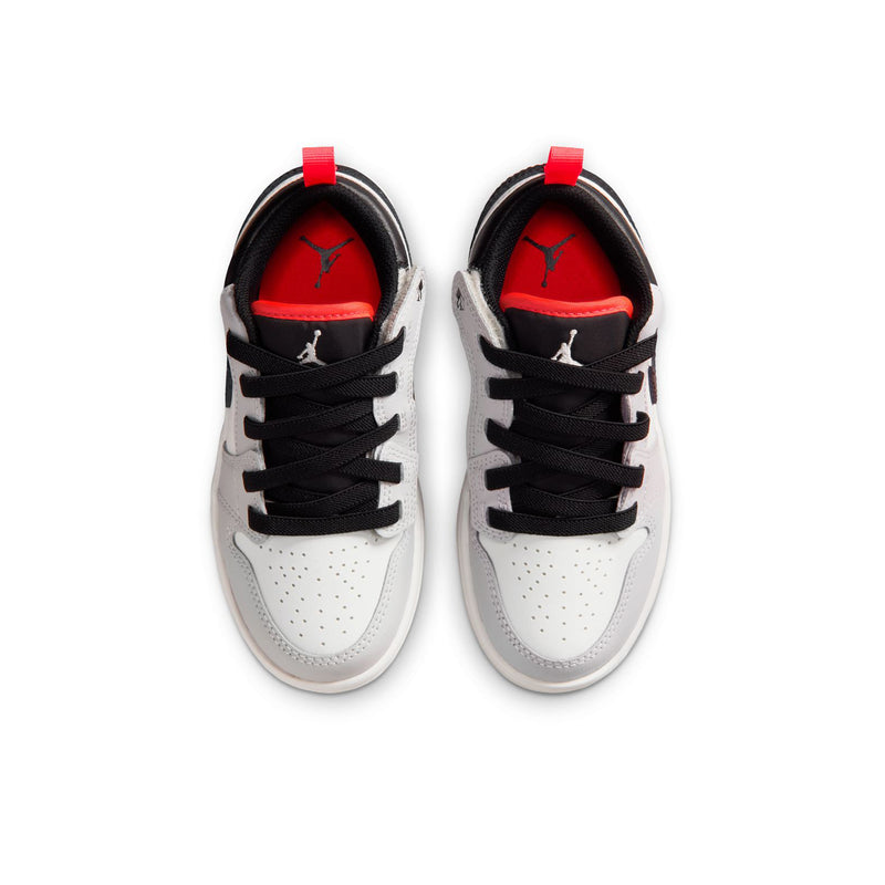 Kids low-top sneakers, front view with black laces, white toe box, red lining