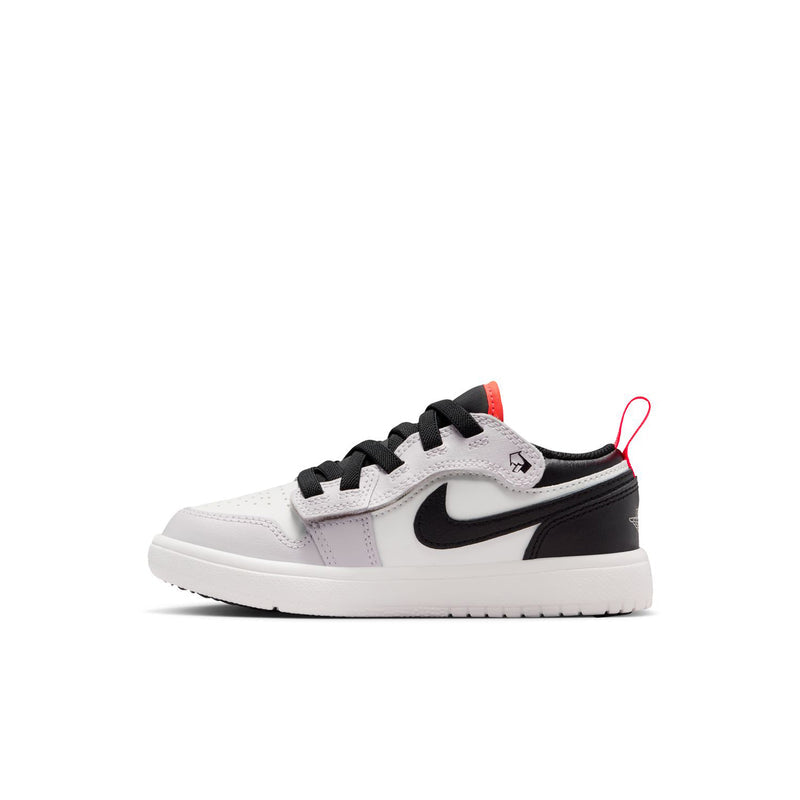 Kids low-top sneakers, side view in white with black swoosh and red lace tag