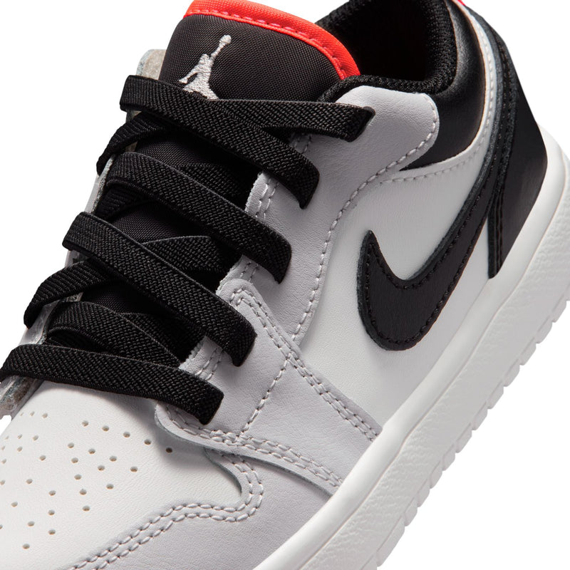 Kids low-top sneakers close-up, black laces, black swoosh, white leather upper