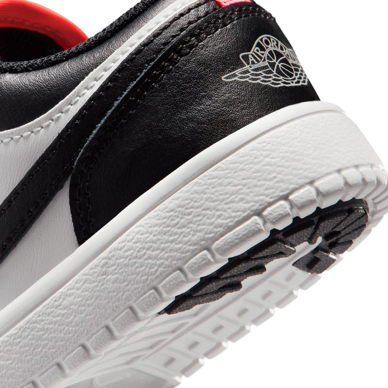 Kids low-top sneakers close-up of side panel and tread, black and white upper