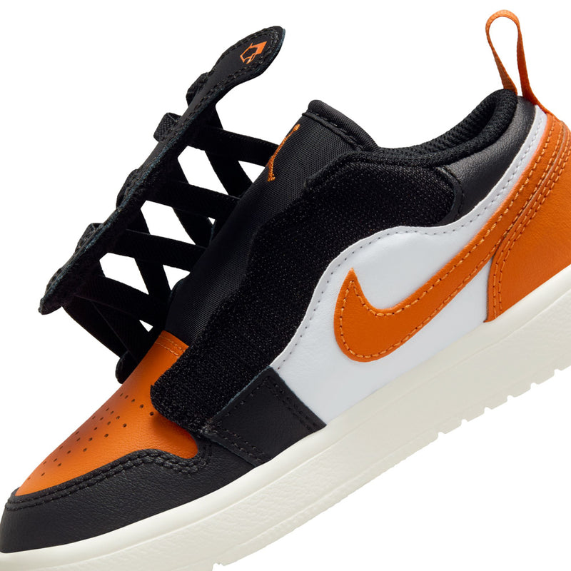 Kids low-top sneakers side closeup, black and orange upper with white Swoosh