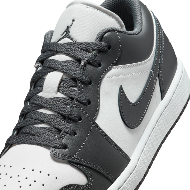 Close-up of dark gray and white low-top sneaker with laces and Swoosh detail