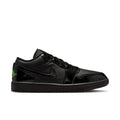 Black low-top sneaker with glossy finish, green accent logo, and lace-up design.