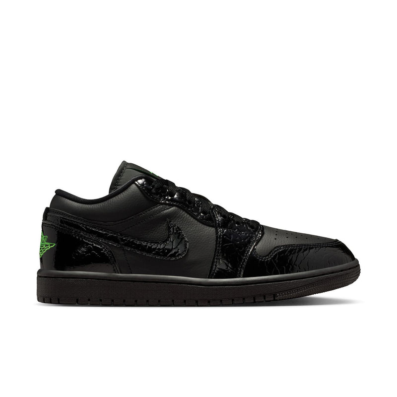 Black low-top sneaker with glossy finish, green accent logo, and lace-up design.