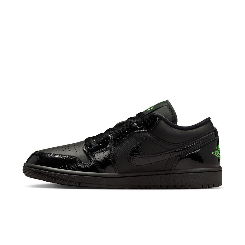 Black low-top sneaker side view with green accent logo and lace-up upper.