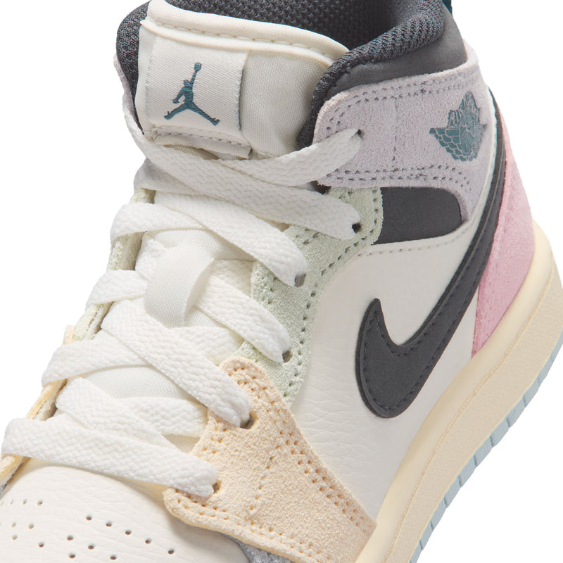 Kids AJ 1 Mid sneaker close-up, white laces with teal wing logo on tongue and collar