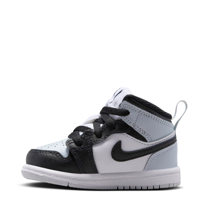 Toddler mid-top sneakers, side view: white upper with black swoosh and lace-up black details